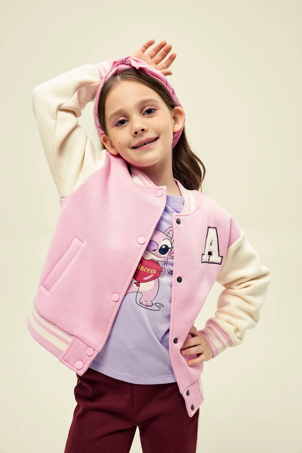 Chaqueta varsity infantil rosada combinada con polera y pantalón para niña