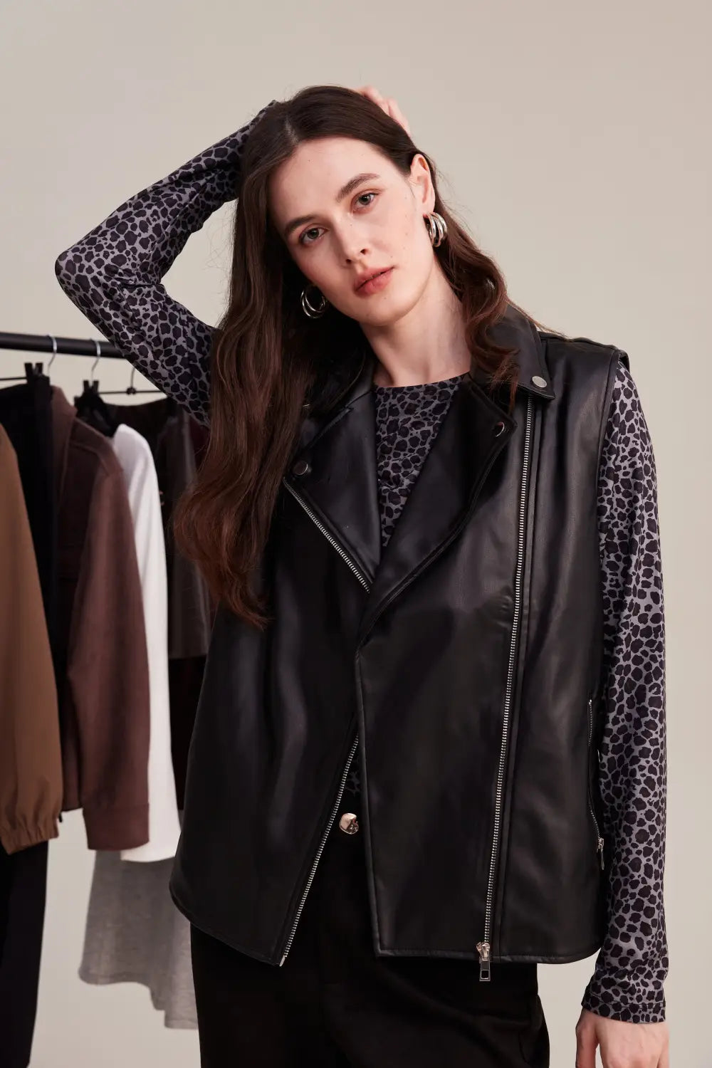 Detalle de look mujer con polera animal print y chaleco sin mangas efecto cuero