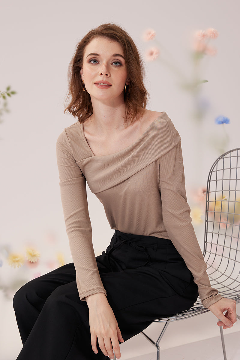 Polera beige de escote drapeado con pantalón negro