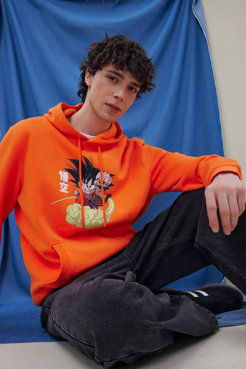 Polerón Dragon Ball naranjo con Goku combinado con jeans negros de hombre